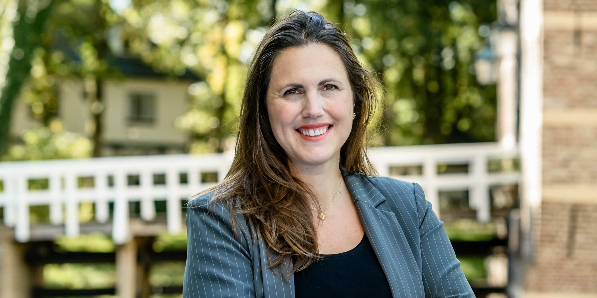 Marieke van de Rakt smiling outdoors in a grey pinstripe blazer